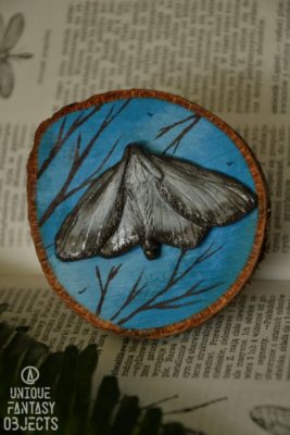 Dekoracja na ścianę lub magnes z ćmą na tle nieba