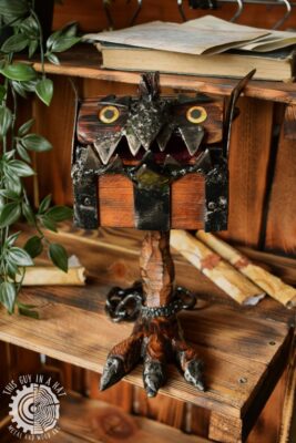 Drewniana skrzynka mimik na kurzej nóżce (This Guy in a Hat)